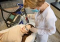 Top view of a young woman receiving facial laser beauty treatment for removing age and pigments spots on her face. Anti-aging