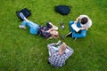 overhead view of young friends reading book and using smartphones