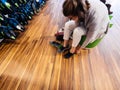 Overhead view of young woman measuring multiple comfortable Crocs shoes inside the dedicated Crocs store - wooden