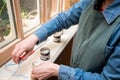 Overhead view of young woman testing paint sample pot of Farrow and ball luxury