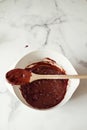 Overhead of wooden spoon on a bowl of chocolate brownie mixture