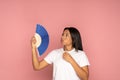 Overheated african woman using paper fan suffer from heat sweating, cools herself, feels sluggish