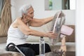 Overheated asian senior woman sweating,high temperature in sunny day while stay at home,cooling herself in front of an electric Royalty Free Stock Photo