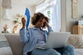 Black woman suffers from heatstroke flat without air-conditioner waving fan sitting on couch at home Royalty Free Stock Photo