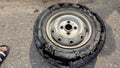 An overinflated car tyre fallen on the road after its tube burst in the street. Royalty Free Stock Photo