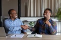 Overjoyed African American business partners shaking hands at meeting