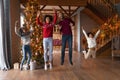 Overjoyed African American family with kids jumping, enjoying winter holidays