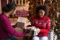 Overjoyed African American man and woman giving Christmas gifts Royalty Free Stock Photo