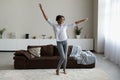 Overjoyed African American woman dancing in modern living room alone