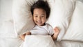 Overjoyed Asian small girl awaken in home bed Royalty Free Stock Photo