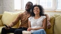 Overjoyed biracial couple have fun watching TV together Royalty Free Stock Photo