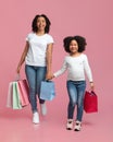 Overjoyed black woman and her cute daughter walking with shopping bags Royalty Free Stock Photo