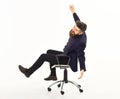 Overjoyed businessman riding in an office chair