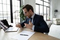 Overjoyed businessman wearing glasses looking at wrist watch, checking time