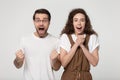 Overjoyed couple feels happy celebrating lucky fortunate moment studio shot