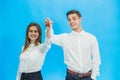 Overjoyed couple with kwys to their new apartments, raising hands up, ready to move as soon as possible. Royalty Free Stock Photo