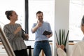 Overjoyed diverse colleagues having fun at meeting, laughing at joke