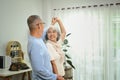 Overjoyed elderly male and female pensioner having fun dancing in living room. Retirement lifestyle concept Royalty Free Stock Photo