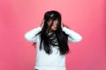 Overjoyed energetic asian young girl waving long brunette hair, ruffle healthy hairs, having fun on pink background Royalty Free Stock Photo