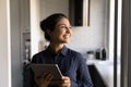 Happy excited mixed race woman dreaming distracted of tablet screen Royalty Free Stock Photo