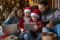 Overjoyed family couple with kids watching funny Christmas cartoons.