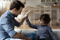 Overjoyed father and little son giving high five, celebrating success Royalty Free Stock Photo