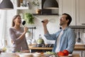 Overjoyed funny family spouses singing songs in kitchen utensils. Royalty Free Stock Photo