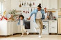 Happy african american family father and little son dancing to music in modern kitchen at home Royalty Free Stock Photo