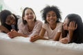 Overjoyed happy sincere young multiracial friends enjoying sleepover party.