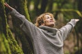 Overjoyed happy woman enjoying the green beautiful nature woods forest around her - concept of female people and healthy natural