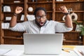 Overjoyed latin black businessman got overwhelming news on laptop
