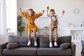 Overjoyed little children brother and sister jumping on sofa at home Royalty Free Stock Photo