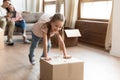 Overjoyed little girl running pushing cardboard boxes in new house. Royalty Free Stock Photo