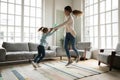 Overjoyed little kid girl having fun dancing with mum.