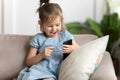 Overjoyed little preschool kid girl playing online game on smartphone.