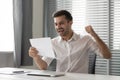 Overjoyed male employee feel euphoric reading pleasant letter