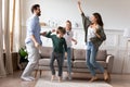 Overjoyed married couple dancing to favorite music with kids.