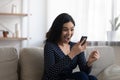 Overjoyed Asian girl triumph reading message on cellphone Royalty Free Stock Photo