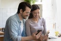 Overjoyed millennial couple have fun using cellphones Royalty Free Stock Photo