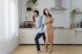 Overjoyed millennial husband and wife dancing in modern kitchen celebrate wedding anniversary at home together, happy young couple Royalty Free Stock Photo