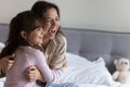 Overjoyed mother hugging laughing little 5s daughter