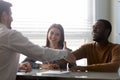 Overjoyed multiethnic couple closing deal signing contract in office Royalty Free Stock Photo