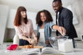 Overjoyed multiethnical parents teaching their child doing bakery while cooking at home. Royalty Free Stock Photo