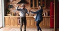 Overjoyed older senior couple dancing in kitchen.