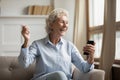 Overjoyed older woman looking at mobile phone screen.