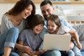 Overjoyed parents with little son and daughter using laptop together Royalty Free Stock Photo