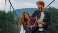 Overjoyed travelers couple cheering on mountain bridge. Active lifestyle concept