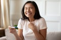 Overjoyed Asian woman get positive pregnancy test result