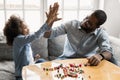 Happy ethnic dad and daughter have fun making bracelets