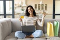 Overjoyed young brunette woman with laptop, shopping bags and credit card making YES gesture, buying things online Royalty Free Stock Photo